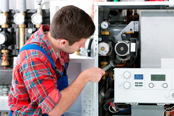 HVAC technician inspecting and repairing boiler controls in Phoenix