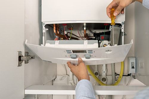 HVAC technician repairing an indoor boiler in Phoenix