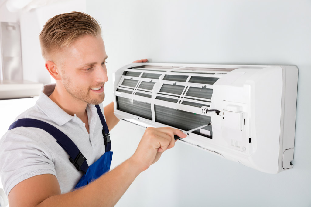 HVAC technician performing ductless air conditioning maintenance in Phoenix