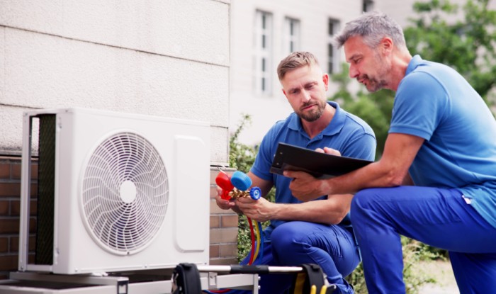 HVAC technicians installing an outdoor air conditioning unit in Phoenix