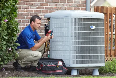 design-air-heating-and-air-conditioning-decatur-il-05 – Copy HVAC technician inspecting an outdoor air conditioning unit in Phoenix, AZ