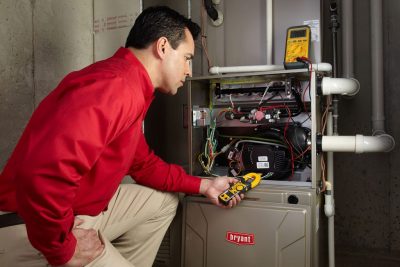 furnace repair Heating and air conditioning technician servicing an indoor furnace in Phoenix, AZ